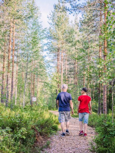 mies ja poika kulkevat metsän keskellä luontopolulla