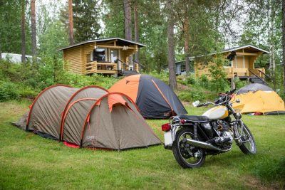 telttoja, mökkejä ja kuvan edustalla moottoripyörä